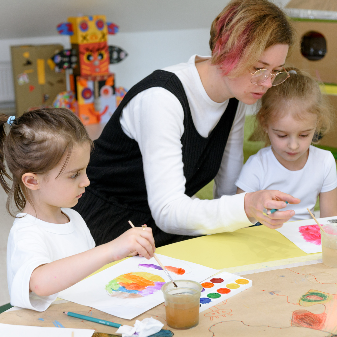Erzieherin und Kinder malen mit Tuschkasten Erzieherin und Kinder malen mit Tuschkasten
